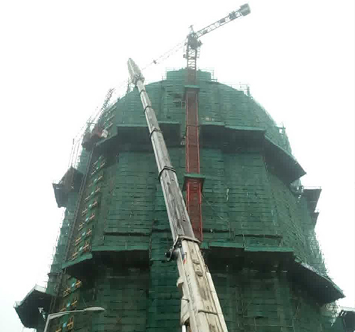 隆回吊车在工地上作业